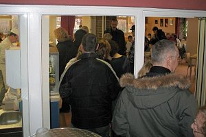 Schlange stehen bei der Essensausgabe Schlange stehen bei der Essensausgabe